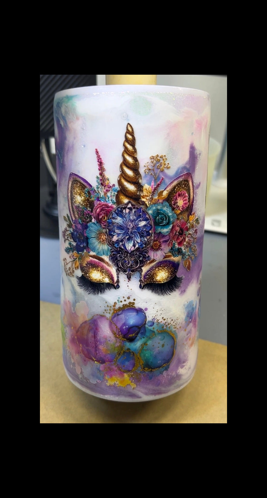 Colorful unicorn-themed tumbler with floral designs on a white background