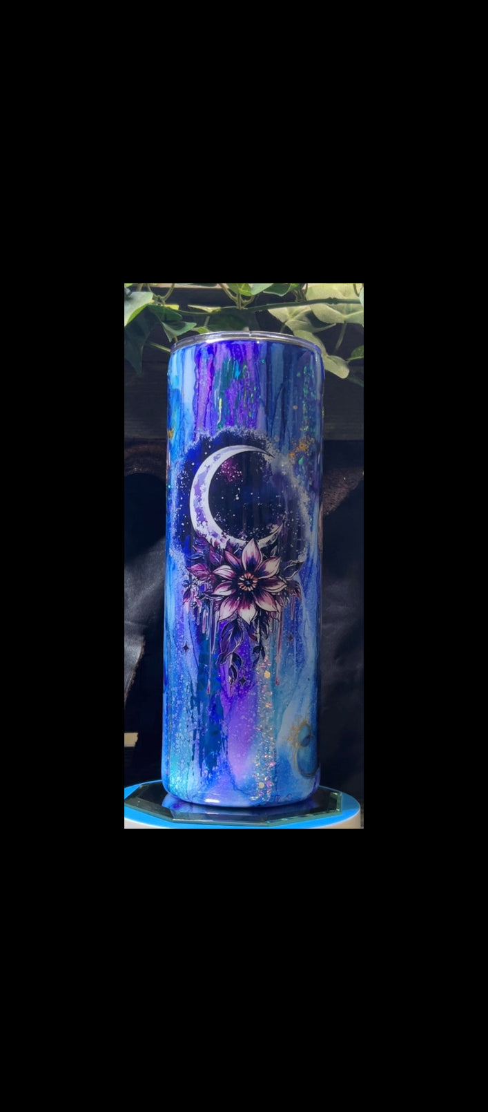 Tumbler with a floral design and moon symbol on a blue gradient background